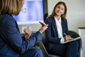Auf dem Bild sind zwei Führungskräfte im Gespräch während eines Trainings zur Führungskräfteentwicklung zu sehen. Sie tauschen sich über Leadership, Mitarbeiterführung und die Gestaltung einer positiven Unternehmenskultur aus. Das Bild veranschaulicht praxisnahe Ansätze wie Coaching, Mentoring und Peer-Learning für nachhaltige Organisationsentwicklung.